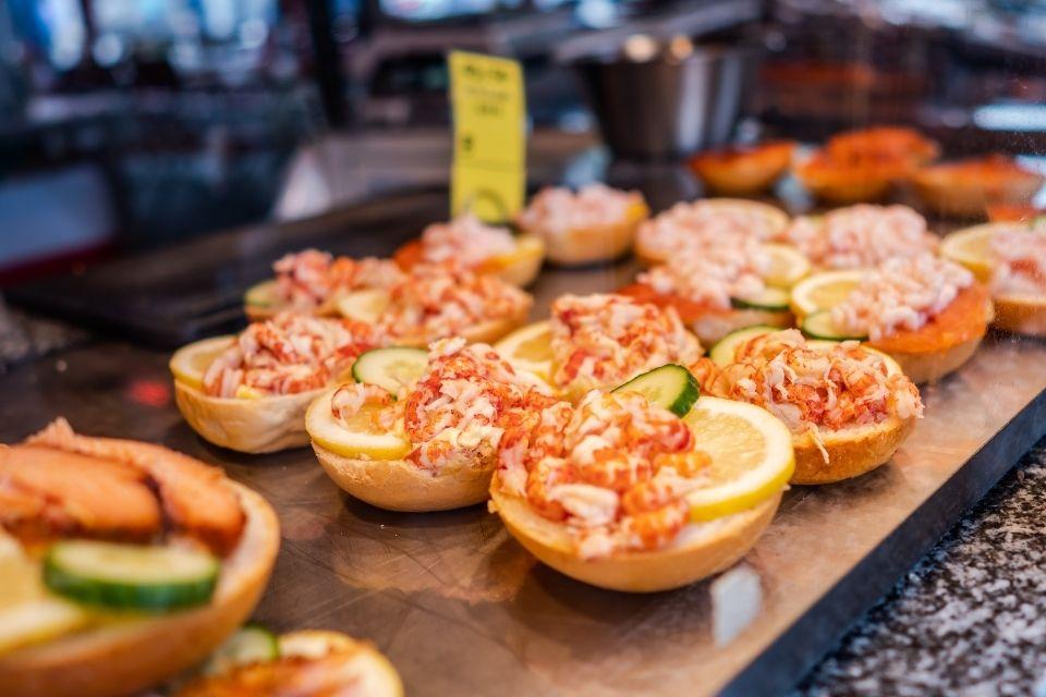 Hapjes met verse vis op de markt in Bergen, Noorwegen